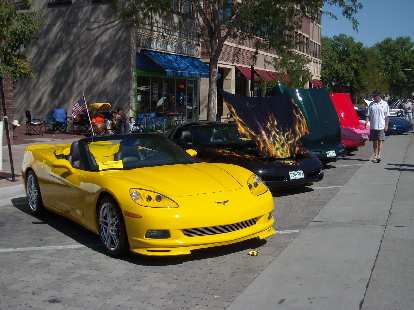 A line of modern Corvettes, including a yellow C6 convertible.
