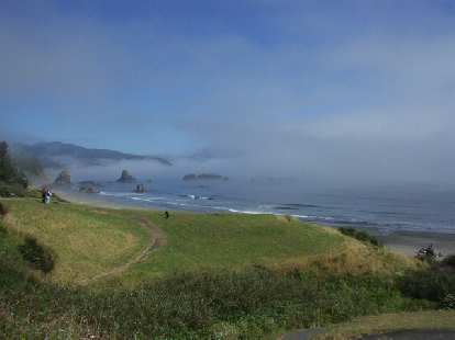 [Battle Rock Wayfinding Point, Port Orford, OR] A beautiful mist overruns a rock coastline while waves crash along the shore.