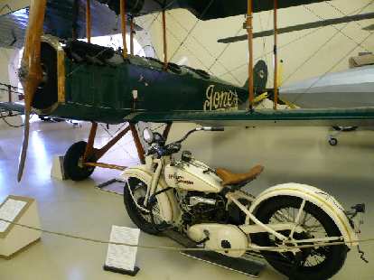 A 1932 Harley Davidson Model V with a 28-hp twin-V and three-speed chain drive, and a plane owned by the Harry Jones Flying Service that gave paid biplane rides in New England.