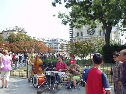 There was a cheery band playing on the sidewalk right in front of the Notre Dame. (17 Aug 2003) There was a cheery band playing on the sidewalk right in front of the Notre Dame.