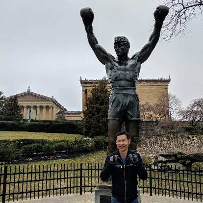 Felix Wong poses as a boxer in front of the Rocky Balboa statue.