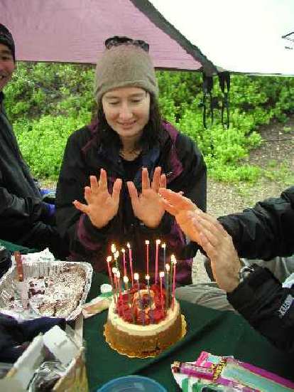 Kathleen and others warming up their hands over the birthday cake! Photo: Adrian Mikolajczak. Kathleen and others warming up their hands over the birthday cake!