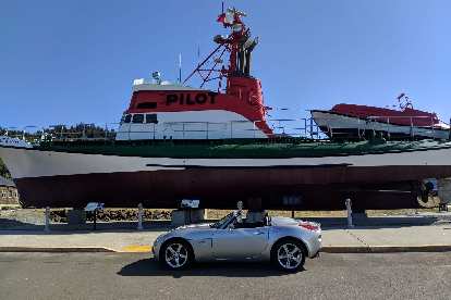 Silver Pontiac Solstice GXP in front of a Pilot ship in Astoria, Oregon.