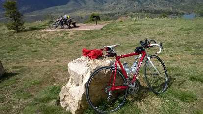 Me and my red Cannondale 3.0 road bike took a little breather as a mountain biker borrowed my pump to inflate his tire in the background. Photo: Person inflating mountain bike tire, red Cannondale 3.0, Fort Collins