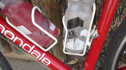 Photo: White water bottle cage, red bicycle, Clif Bar wrapper shim