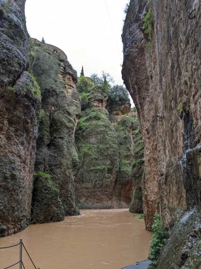 The muddy water of the Guadalevin River through a canyon.