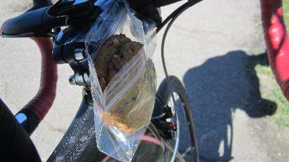 I taped a sandwich bag to the side of the stem in order to contain food while eating. cookie, sandwich bag, taped to stem of bicycle