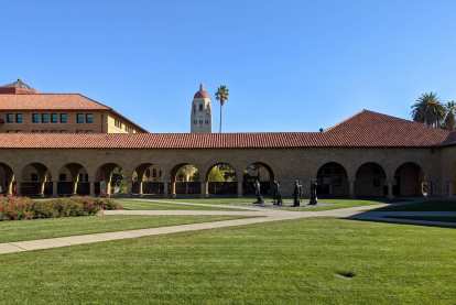 Grass outside the Quad at Stanford University, with the Hoover Tower and a giant palm tree behind.