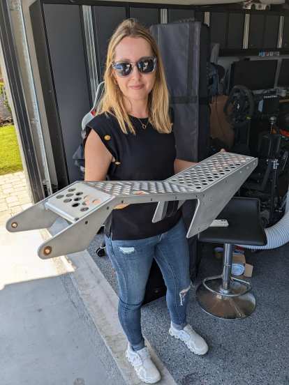 Andrea holding the lightweight seat frame of a Ryvid Anthem prototype.