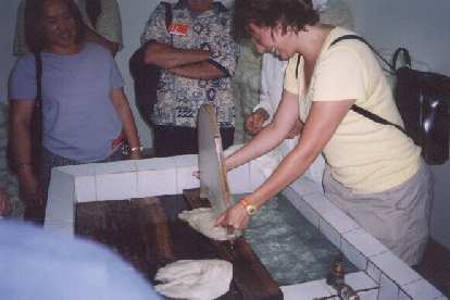 Karen stretching balls of silk into thinner pieces using this strongarm device.