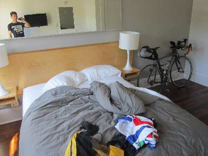 Felix Wong's room at the Norblad Hotel in Astoria Oregon two days before the 2015 Trans Am Bike Race. (05 Jun 2015) Image: Cycling clothes on bed and black Litespeed Archon C2 in cabin room of Norblad Hotel in Astoria, Orego.