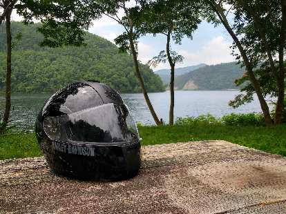 A black Harley-Davidson full-face helmet on a picnic table by Chilhowee Lake in Tennessee. A black Harley-Davidson full-face helmet on a picnic table by Chilhowee Lake in Tennessee.