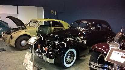 A black 1937 Cord 812 front wheel drive car with supercharger and rectractable headlights in the front fenders.