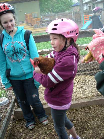 Girl holding a chicken.