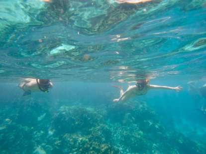 Felix and Andrea snorkeling over coral reef tops in Honaunau Bay.