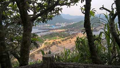 The view of buildings on the Yehliu Peninsula through trees at Yehliu Geopark. Photo: The view of buildings on the Yehliu Peninsula through trees at Yehliu Geopark.