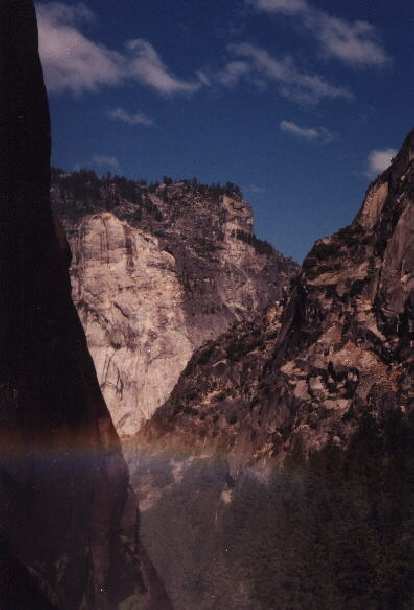 Another pretty rainbow overshadowed by the towering cliffs of Yosemite. Another pretty rainbow overshadowed by the towering cliffs of Yosemite.