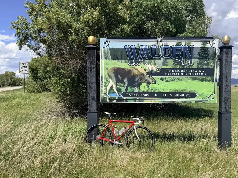 My red Cannondale in front of the "Walden, the moose capital of the world" sign.