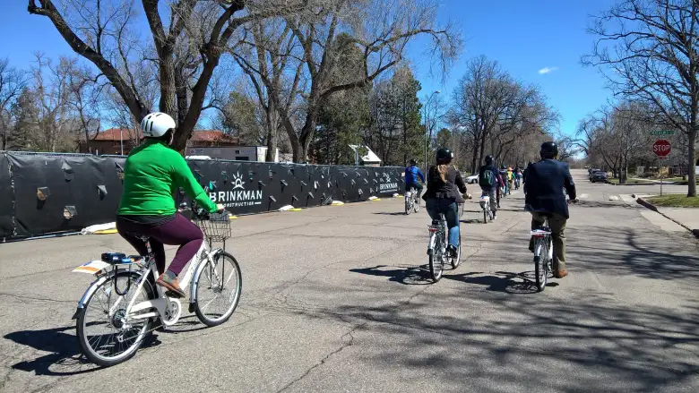 Ceremonial parade after the unveiling of the Fort Collins Bike Share program. woman in green jersey riding white Zagster bicycle, other cyclists