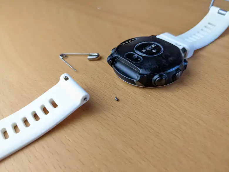 The Garmin Forerunner 645 Music watch with a broken watch pin support, the new watch pin collar I made, and the white watchband.