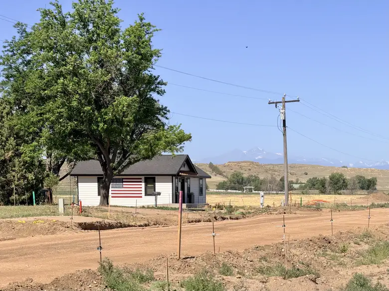 A lone home with an American flag painted on the side of the house had a nice view of Mount Meeker and Longs Peak. A lone home with an American flag painted on the side of the house had a nice view of Mount Meeker and Longs Peak.