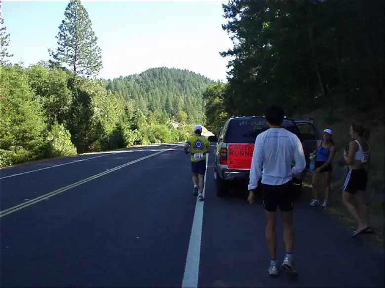 [Mile 6, 1:06 elapsed, 1:36 p.m.] As we would do for almost every leg, we stopped off midway to offer water and support.  That's Phil running with Everitt, Lisa, and Heidi cheering on.  You can see the gas-guzzling Chevy Tahoe with non-folding middle seat in this picture too.