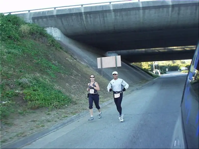 [Mile 141, 19:35 elapsed, 8:05 a.m.] Here's Heidi on her third and last leg, running with just one of the half dozen or so completely random guys who'd become enamored with her during the race.  This dude even bought her a chai from Starbucks afterwards!