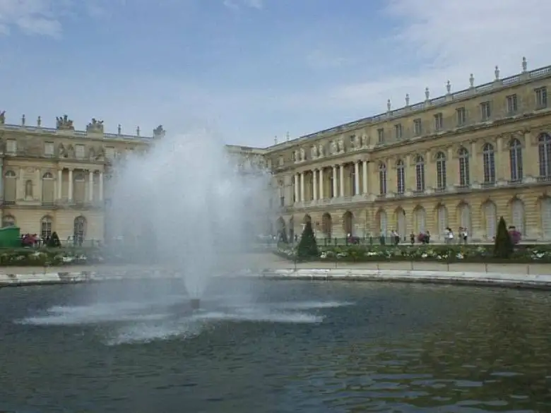 Closeup of a fountain, and rear view of Le Chateau.