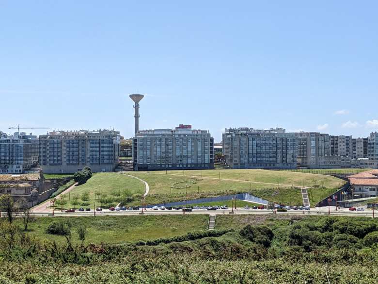Apartment buildings overlooking a greenbelt near the Hercules Tower in A Coruña.