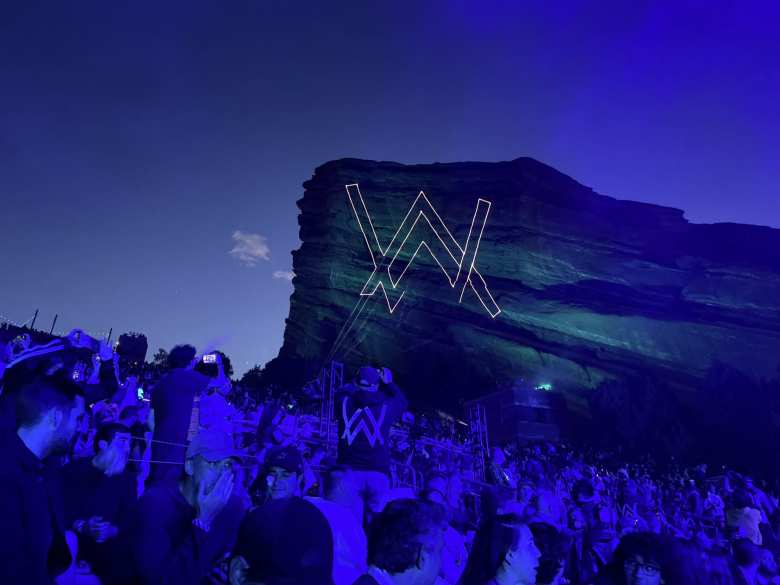 The Alan Walker symbol projected onto Red Rocks like the Bat Symbol.