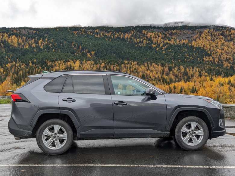 Our dark gray 2021 Toyota RAV4 rental SUV with Alaskan fall colors in the background.