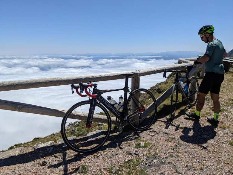 My Litespeed Archon C2 with Marcos and his Ghost road bike leaning against wooden rails above the clouds at the Angliru.