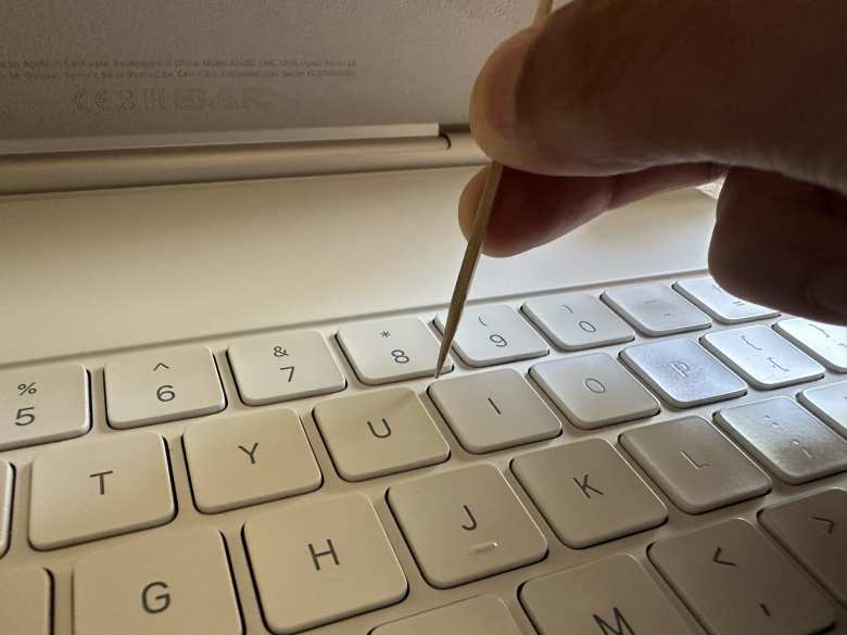 Applying the white model paint to the corner of the I key.