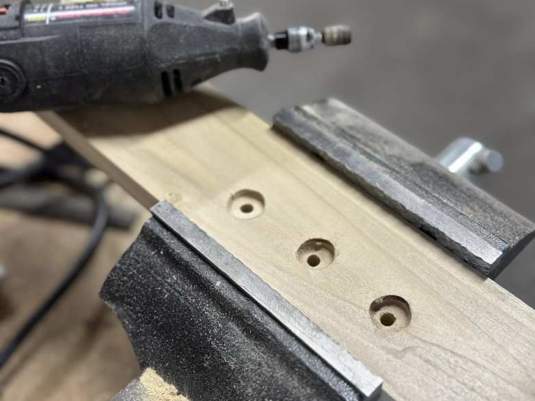 I used a Dremel tool to create counterbored holes on the bottom of the wood base for the fork mount. This would allow me to recess the nuts for the bolts.