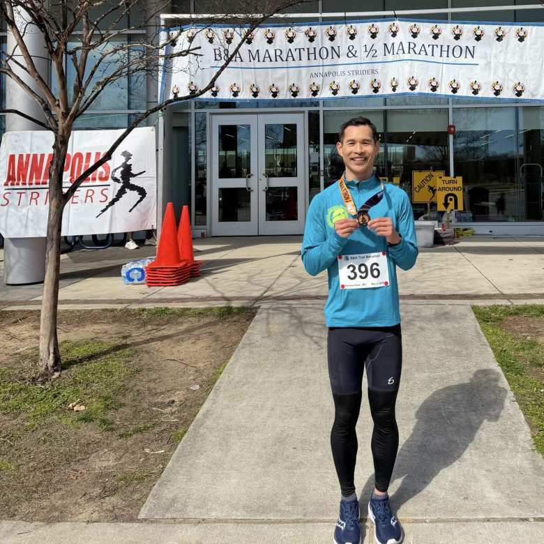 Felix Wong holding his finishing medal after completing the B&A Trail Marathon.