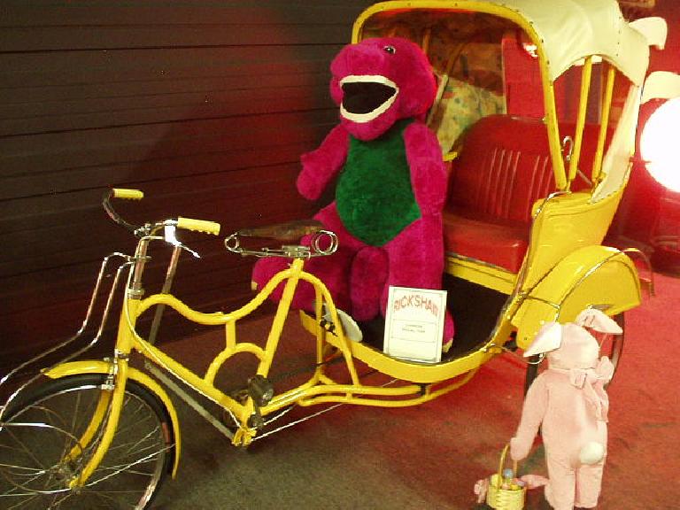 This is a Chinese rickshaw carrying Barney, the purple dinosaur.