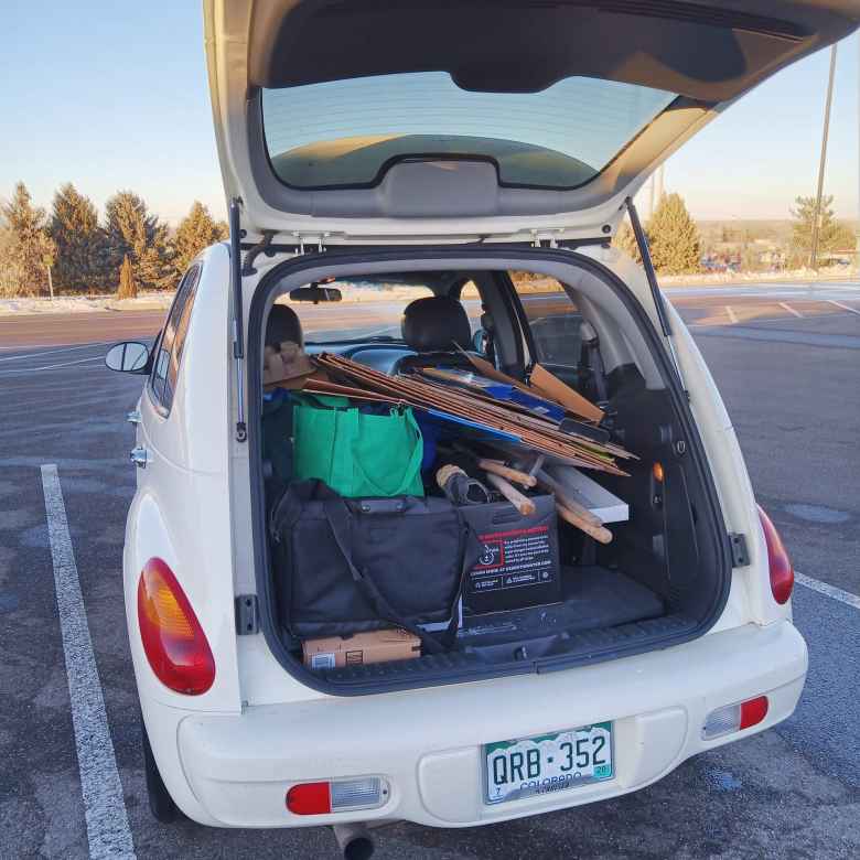 white 2005 Chrysler PT Cruiser, carboard boxes and cloth bags in cargo space, hatch open