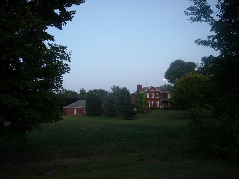[Mile 411] The full moon over a red house.