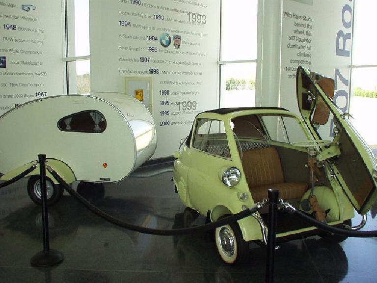 An Isetta with a trailer in tow, as if the Isetta actually had enough power to tow it.