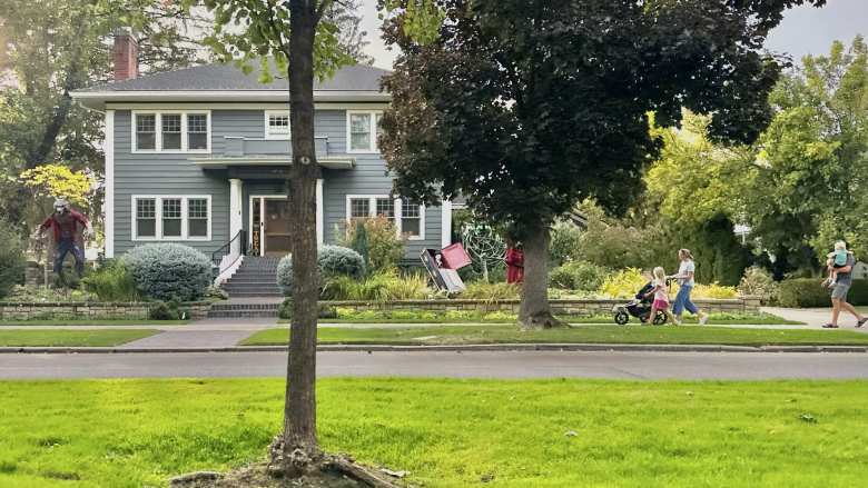 A family walks by an elaborately decorated house on North Harrison Boulevard in Boise, Idaho.