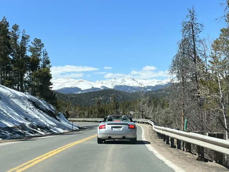 Driving my silver Audi TT Roadster Quattro with the top down towards the snow-capped Rocky Mountains on Highway 72 east of Nederland, Colorado.