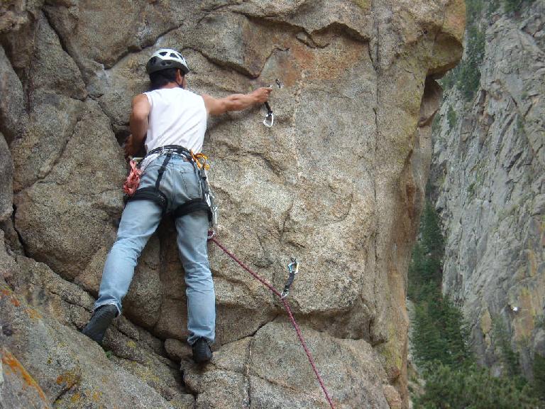 Clipping the second bolt on Qs (5.9+) in The Boulderado area.