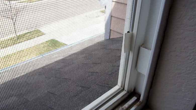 A window screen pull tab made from white duct tape.