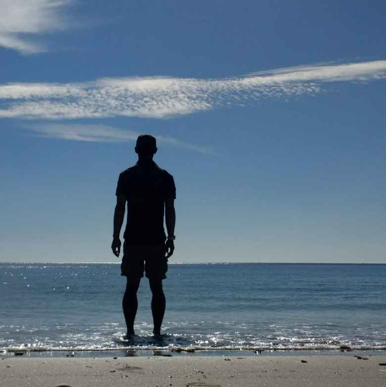 Felix Wong dipping his toes in the water on a beach a few miles from the official end of the Camino de Fisterra.