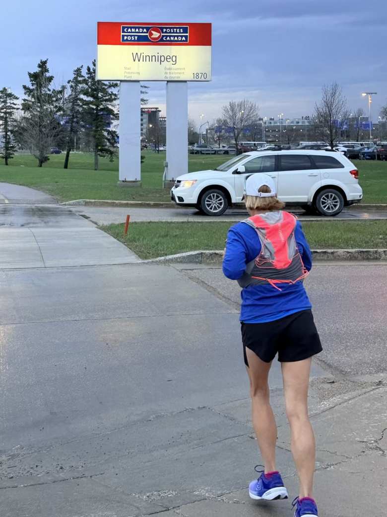 Mel running towards a Winnipeg sign.