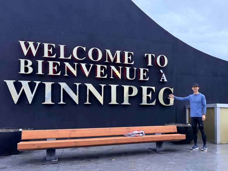 Felix next to a welcome sign in Winnipeg.