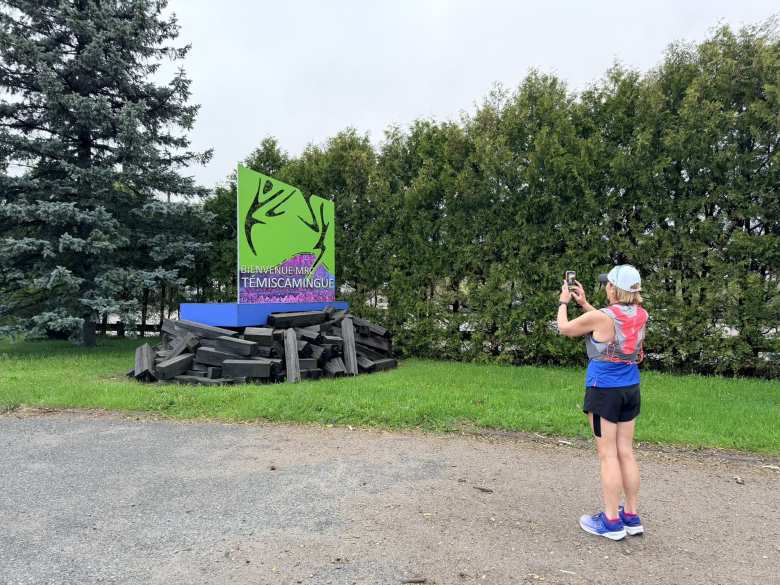 Mel taking a photo of the welcome sign in Temiscaming.