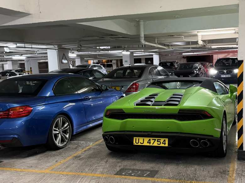 A green Lamborghini Huracán LP610-4 Spyder (2016-2019) parked next to a blue BMW 4 Series Convertible (2014-2017).