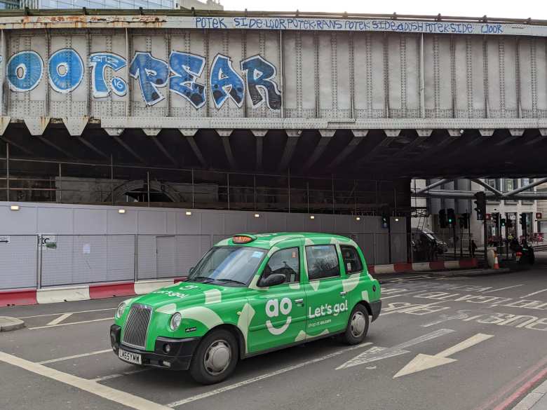 A green London Taxi sponsored by AO.