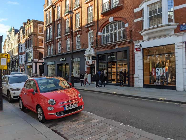 An orange Fiat 500 on the streets of London.